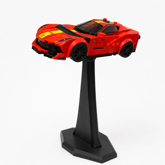 Red toy car on a black stand against a white background
