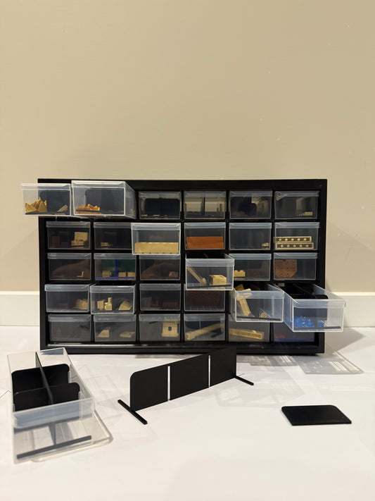 Black storage cabinet with transparent drawers against a beige wall.
