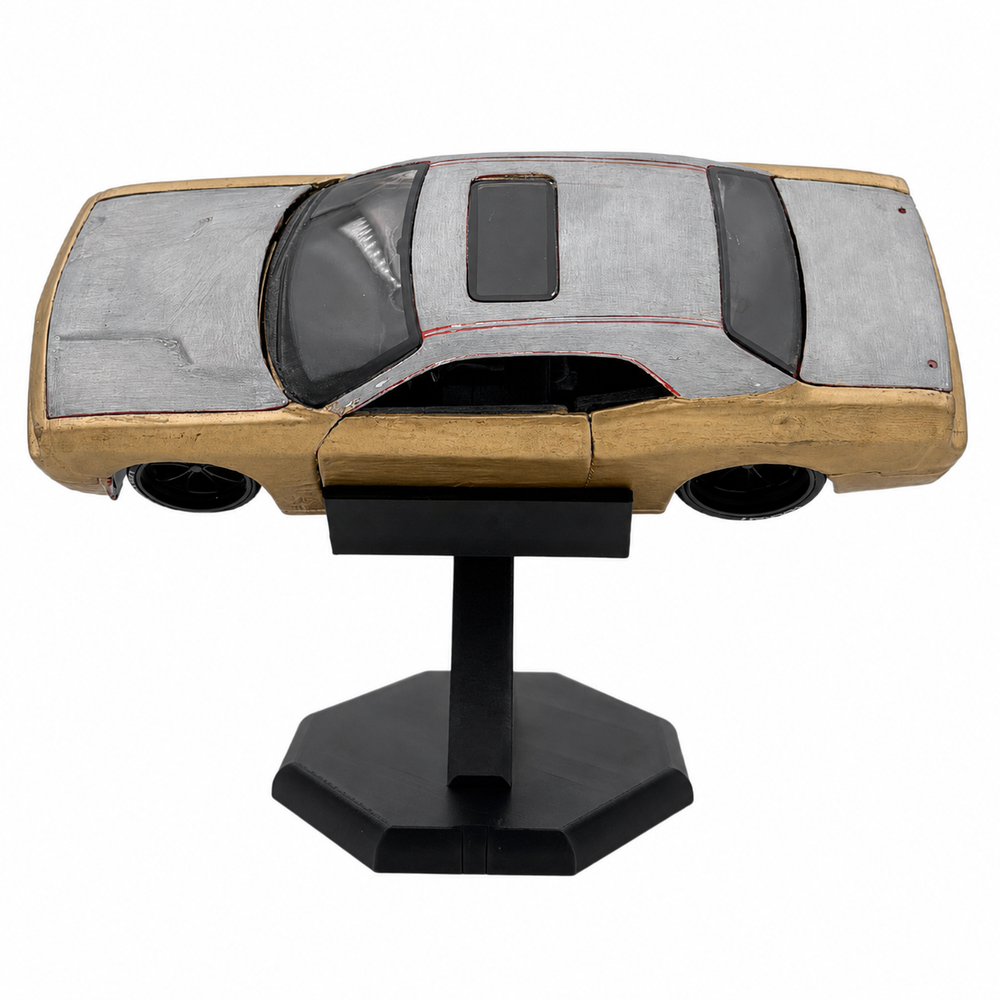 A scale model of a classic car with a silver-gray textured roof, a light wood-grained body, and a black stand, shown against a plain white background.